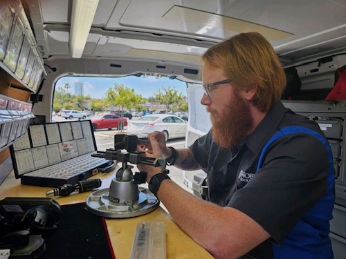 Our locksmith rekeying a lock cylinder inside his Noble Locksmith van.