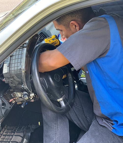 Javier repairing an ignition in a Chevy.